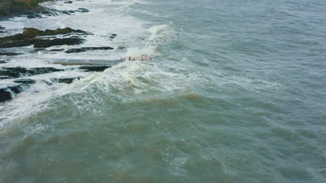 Aerial-view-of-waves-crashing-against-rocks-along-the-coastline