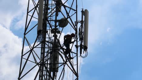 Man-loosening-cell-tower-antenna--for-upgrading