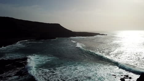 Aerial-of-waves-crushing-into-rocks-and-beach,-Lanzarote