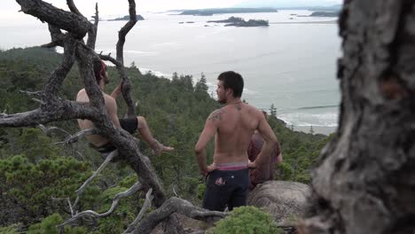 Three-young-men-looking-at-the-coastline-of-Tofino-Bay,-Vancouver-Island-British-Columbia,-Canada,-Walking-Dolly-Shot