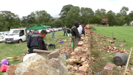 Concursos-De-Muros-De-Piedra-Seca-En-La-Feria-Agrícola-De-Brough-En-Cumbria,-Donde-Los-Competidores-Tienen-Su-Propia-Pequeña-Sección-De-Muro-Para-Construir,-Que-Luego-Se-Juzga-Según-Su-Calidad-De-Construcción.