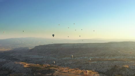 Many-colorful-hot-air-balloon-flight-above-Goreme-Valley-Cappadocia-at-summer-morning---Aerial-drone-view