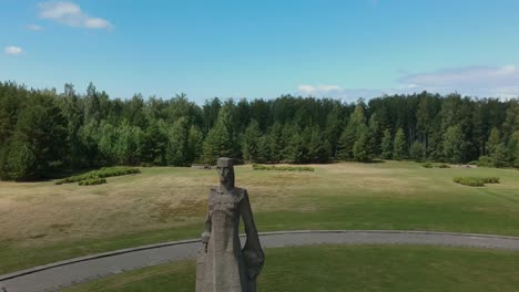 Luftaufnahme-Einer-Frau,-Die-Sich-Auf-Eine-Riesige-Statue-Zubewegt,-Die-Ihr-Kind-Versteckt