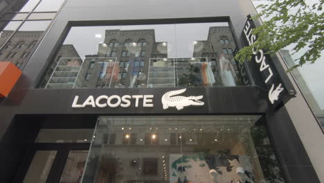 Editorial,-4K-View-of-Lacoste-showcase-store-and-people-passing-in-street