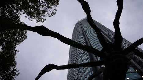 Time-lapse,-tilt,-shot,-of-a-skyscrapers,-at-the-Roppongi-hills-area,-on-a-cloudy-day,-in-Japan