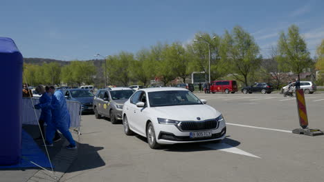 Weite-Aufnahme-Von-Menschen-In-Autos,-Die-Darauf-Warten,-Im-Zweiten-Drive-Through-Impfzentrum-Für-Covid-19-In-Rumänien-An-Der-Reihe-Zu-Sein,-Um-Den-Pfizer-Biontech-Impfstoff-Zu-Erhalten