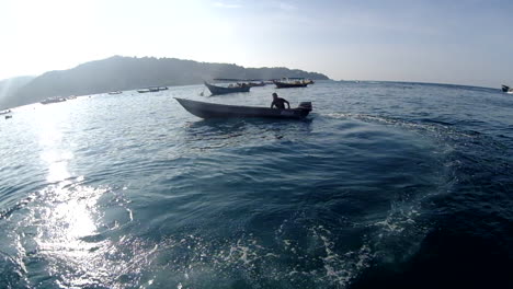 Man-Sailing-On-A-Boat-Taxi-In-Perhentian-Islands,-Terengganu,-Malaysia-On-A-Sunny-Day---fisheye-view,-low-level-shot