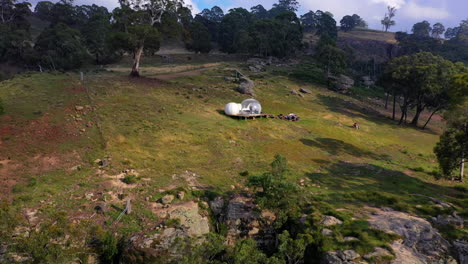 Secluded-bubble-tent-at-the-edge-of-a-cliff,-aerial-pull-back