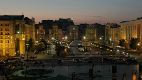 Imagen-Elevada-Al-Anochecer-Del-Tráfico-En-Hora-Punta-En-La-Calle-Khreschatyk-Kiev-Con-La-Plaza-Maidan-Detrás