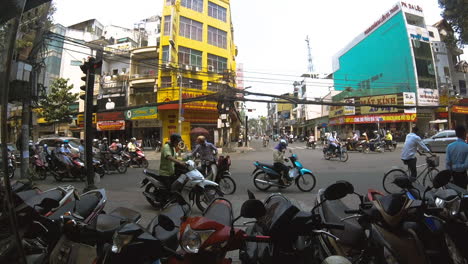 Cityscape-at-traffic-on-crossroads-at-rush-hour-with-scooters,-Ho-Chi-Minh-city,-Vietnam