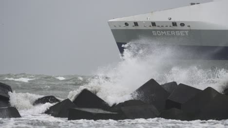 Zeitlupenaufnahme-Eines-Schiffs,-Das-Aus-Einem-Hafen-Ausläuft,-Während-Die-Wellen-über-Den-Steg-Brechen