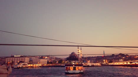 Unidentfied-people-have-Istanbul-boat-tour-with-view-of-bosphorus-and-New-Mosque-at-sunset-in-istanbul,Turkey