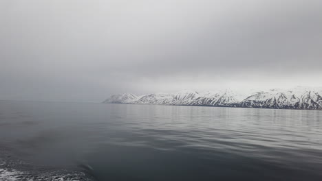 Beautiful-view-from-a-boat-in-Icelandic-fjord-with-silver-water-and-white-Mountain-View