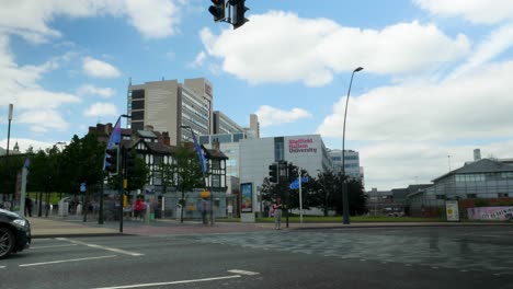 Timelapse-De-Personas-Cruzando-Cerca-Del-Cine-Show-Room-De-Howard-Street-Con-La-Universidad-Sheffield-Hallam-Al-Fondo-Caminando-Hacia-Y-Desde-La-Estación-De-Tren-De-Sheffield-Con-Autos-Pasando-4k-25p