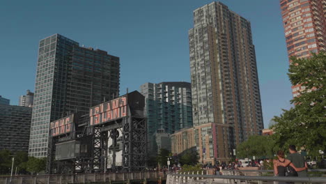 Wide-shot-of-Long-Island-City-sign-with-skyscrapers-and-a-couple-walking-by