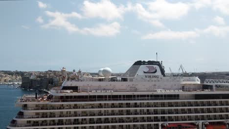 Timelapse-of-Viking-cruise-ship-docked-in-Port-of-Valletta-before-embarking-with-Three-Cities-in-the-Background,-Malta