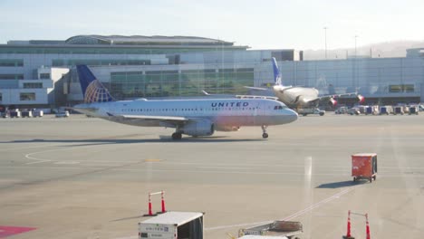 Handheld-shot-of-united-airlines-plane-as-it-taxis-to-main-runway-during-golden-hour-at-san-Francisco-international-airport