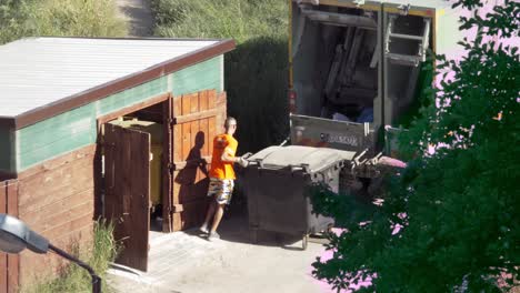 Hombre-Vacía-Botes-De-Basura-En-Un-Camión-De-Basura