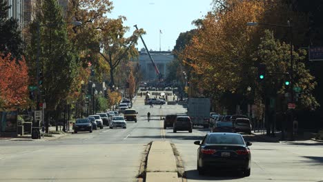 Wide-shot-from-avenue-with-driving-cars-during-sunny-day-and-white-house-in-background