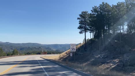 3-De-Abril-De-2022--Dakota-Del-Sur,-Estados-Unidos:-POV-Desde-La-Perspectiva-De-Un-Conductor-En-Una-Carretera-Arbolada-Con-Un-Cielo-Azul-Claro