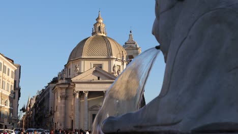 Sesión-Estática-Para-La-Fuente-Del-León-Con-Turistas-Y-La-Iglesia-De-Los-Artistas-De-La-Plaza-Del-Pueblo-Al-Fondo