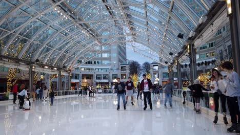 Niños-Y-Padres-Patinan-Juntos-En-Una-Pista-De-Patinaje-Sobre-Hielo-En-Un-Centro-Comercial-Al-Aire-Libre