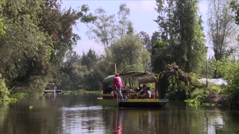 Totale,-Mexikanischer-Arbeiter-Fährt-Ein-Traditionelles-Boot-In-Xochimilco,-Genannt-Trajinera