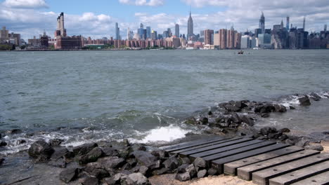 Inclínese-Hacia-Arriba-Desde-La-Playa-Greenpoint-En-El-Lado-De-Brooklyn-Del-East-River,-Revelando-El-Centro-De-Nueva-York