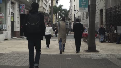 Toma-En-Primera-Persona-De-Walker-De-Gente-Caminando-En-La-Calle-Sarandi,-Montevideo.