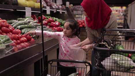 Mother-and-daughter-bagging-tomatoes-at-the-supermarket