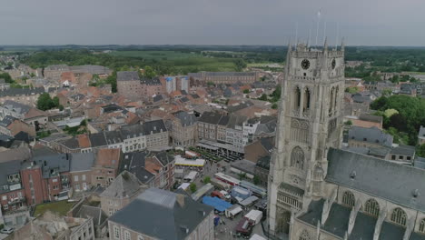 AERIAL:-A-market-on-a-church-square-in-the-centre-of-the-city-with-a-view-on-the-city's-basilica