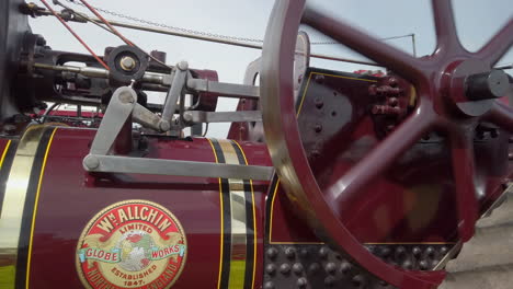 Close-up-of-the-side-of-a-red-vintage-traction-engine-in-operation