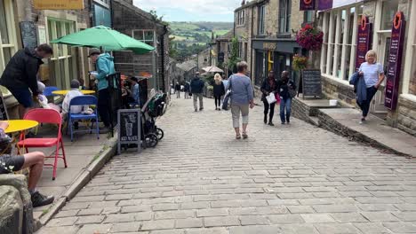 Haworth-Main-Street-with-cobbled-road-and-and-people-walking-along-shopping-and-filled-with-tourists