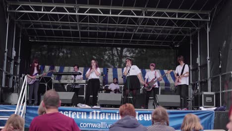 English-Band-Performing-On-Stage-With-Audience-During-The-Royal-Cornwall-Show-2019-In-Cornwall,-United-Kingdom---low-angle-wide-shot