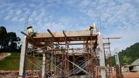 Construction-workers-installing-timber-form-works-and-rain-water-down-pipes-at-the-construction-site