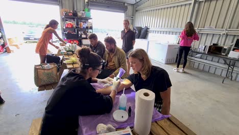 Shot-of-a-tourist-girl-getting-a-homemade-tattoo-in-a-shed-in-New-Zealand