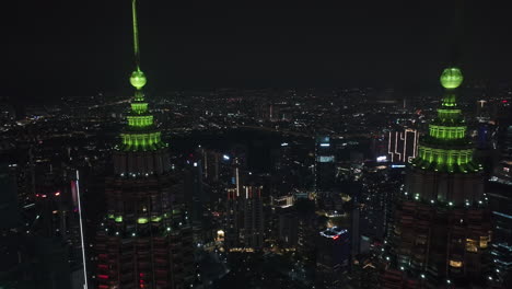 Drone-flying-backwards-betweenf-the-Petronas-Towers,-in-Kuala-Lumpur,-Malaysia