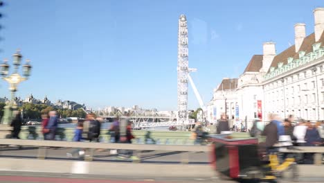 Kurze-Fahrt-über-Die-Westminster-Bridge-In-London-Mit-Blick-Auf-Die-Touristenbusse,-Das-London-Eye-Und-Das-Umgebaute-Hotel-County-Hall