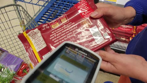 People-using-Zebra-scan-as-you-shop-scanner-to-price-groceries-as-they-shop-in-Tesco-supermarket-store-in-England-UK