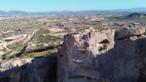 Deportistas-Escalada-En-Roca-Vista-Aérea-De-La-Montaña-De-Rappel-Deportista-En-La-Panocha,-El-Valle-Murcia,-España-Mujer-Rapel-Bajando-Una-Montaña-Escalando-Una-Gran-Roca