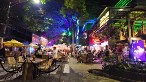 Crowded-street-in-El-Poblado,-people-having-a-good-time-at-nighttime,-Medellin