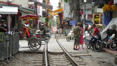 Busy-railway-crossing,-motorbikes,-traffic,-transport,-vehicles,-people