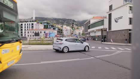 Busy-Funchal-city-street-intersection,-car-stop-at-pedestrian-crosswalk,-Madeira