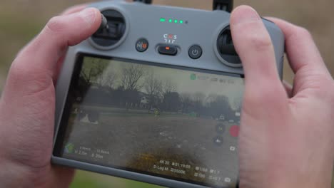 Live-view-of-screen-on-drone-controller-in-hands-while-flying-low-outdoors