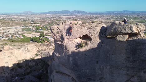 Deportistas-Escalada-En-Roca-Vista-Aérea-De-La-Montaña-De-Rappel-Deportista-En-La-Panocha,-El-Valle-Murcia,-España-Mujer-Rapel-Bajando-Una-Montaña-Escalando-Una-Gran-Roca