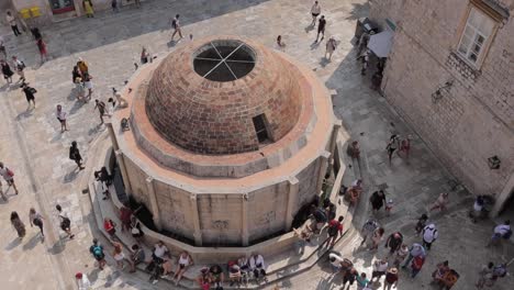 Gente-Moviéndose-En-La-Muralla-De-La-Ciudad-Del-Edificio-Con-Forma-De-Cúpula-De-Dubrovnik,-Croacia.