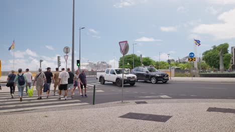 People-cross-street-on-crosswalk-near-roundabout-traffic-light,-Madeira