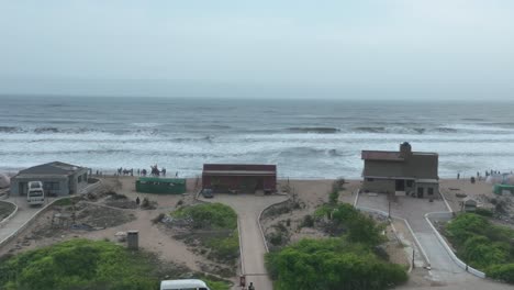 Drone-flies-at-the-WWF-Wetland-Centre-in-Karachi---houses-on-the-beach-and-you-can-see-the-sea-with-big-waves-and-people-standing-on-the-beach