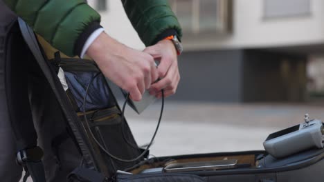 Videofilmer-Lädt-Telefon-Aus-Der-Powerbank-Des-Drohnenakkus-In-Einer-Offenen-Kameratasche-Auf