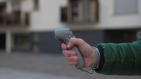 Side-view-of-hand-holding-and-using-a-DJI-FPV-Motion-Controller-for-drone-operation